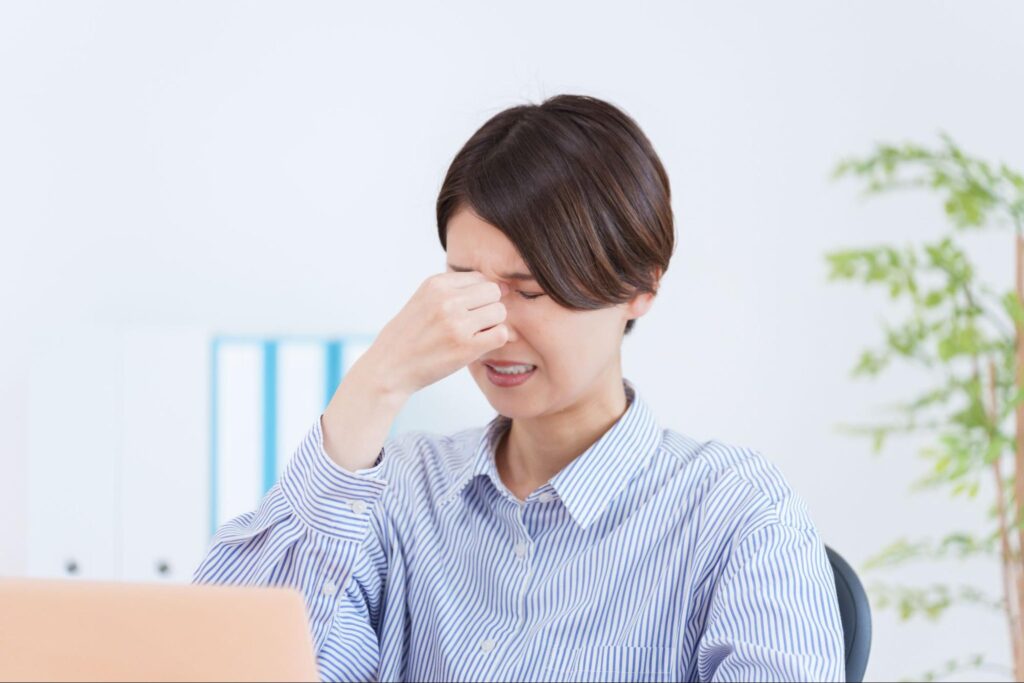 目を押さえている重症のドライアイの女性