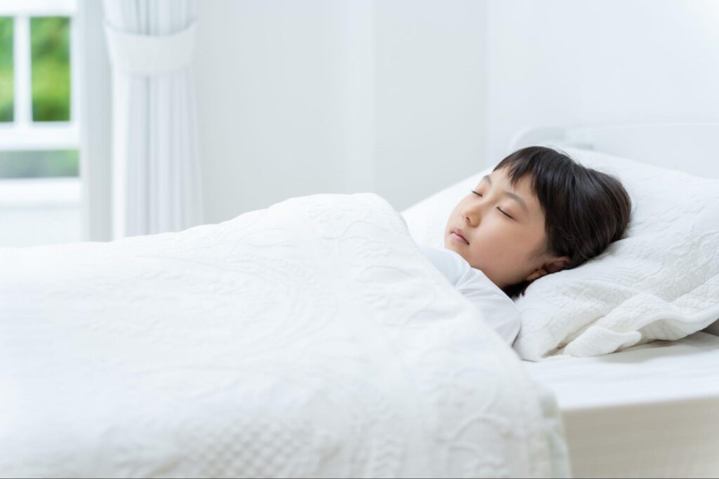 ベッドで眠っている子ども