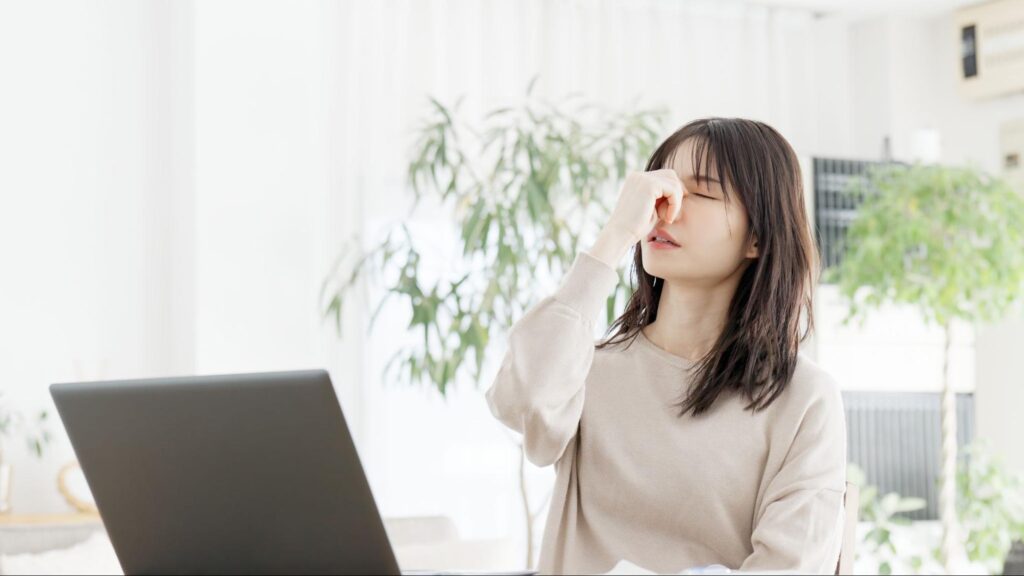 目を押さえている重症のドライアイの女性