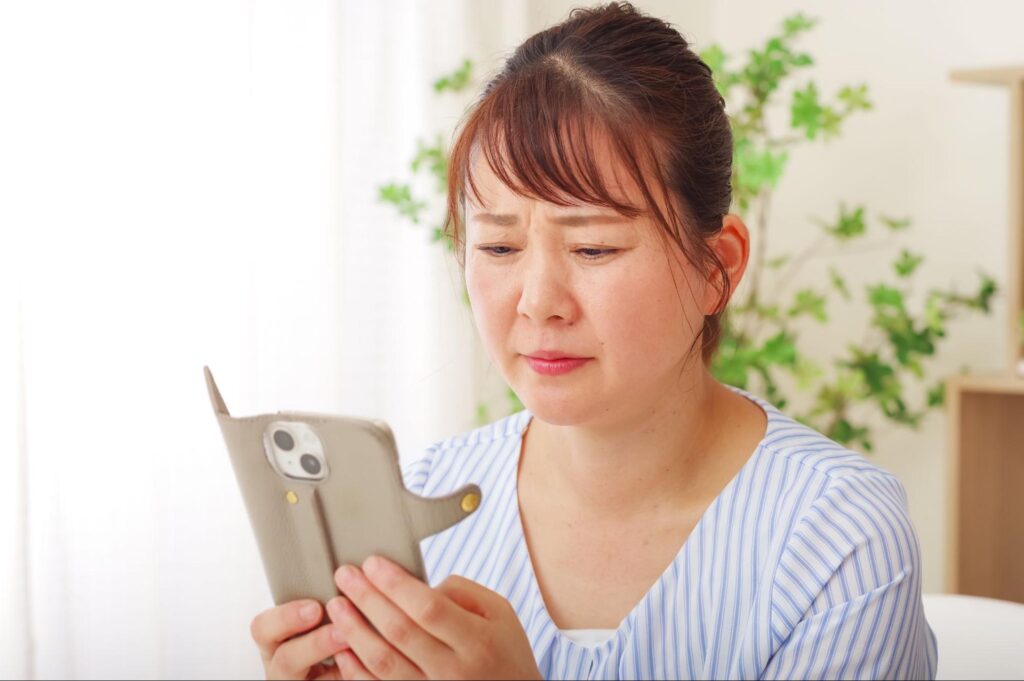 スマホを見ているドライアイの女性